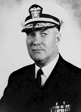 Black and white portrait of Walden L. Ainsworth in a dark Navy officer's uniform and a cap with gold braid