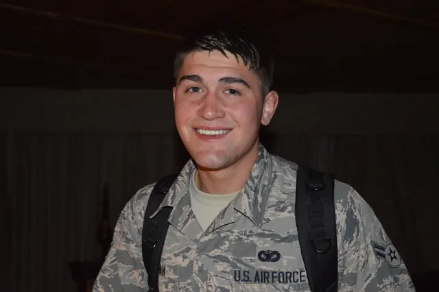 Brandon Sullivan as a young airman, smiling in his Air Force camouflage uniform with backpack straps over his shoulders