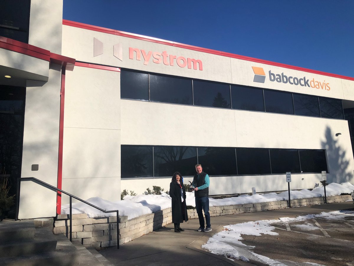 The Employer of the Year award presented outside Nystrom's building, with the Nystrom and Babcock Davis signs above