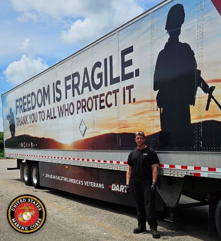Brian Kerkow beside a Dart trailer painted with a soldier silhouette and the words Freedom Is Fragile