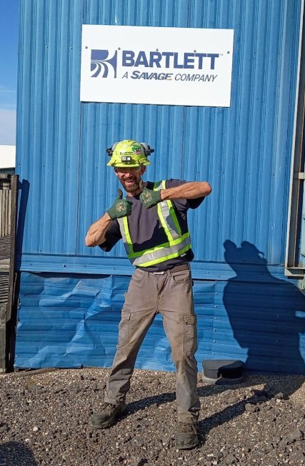 Jeffrey Hyde in safety gear outside a blue Bartlett building