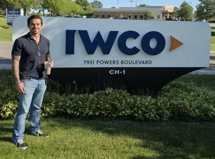 Noah Johnson beside the IWCO sign