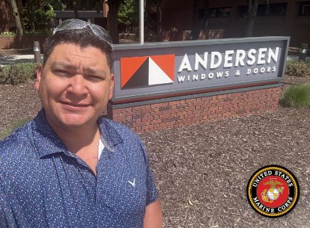 Valente Vasquez in front of the Andersen Windows and Doors sign